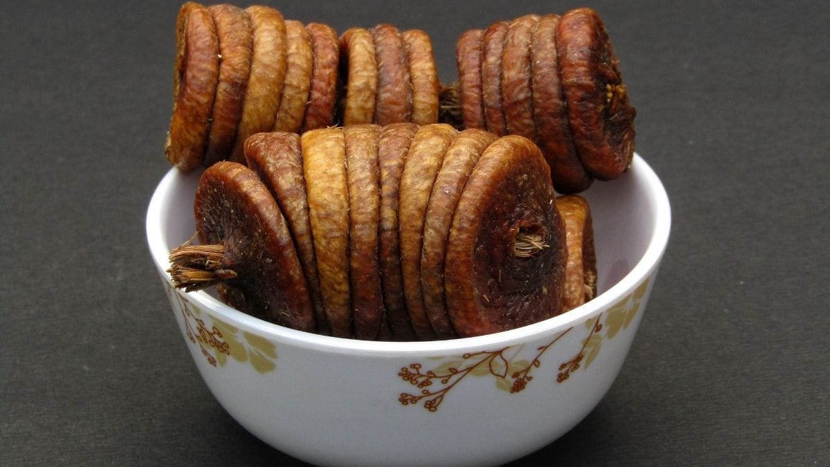 Natural brown organic sun-dried figs in ceramic bowl showing authentic clean label appearance without sulfur dioxide treatment